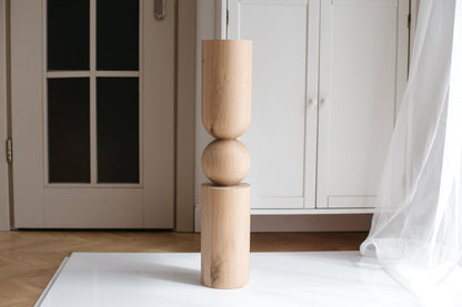 Wooden sculpture on a white rug with a neutral background
